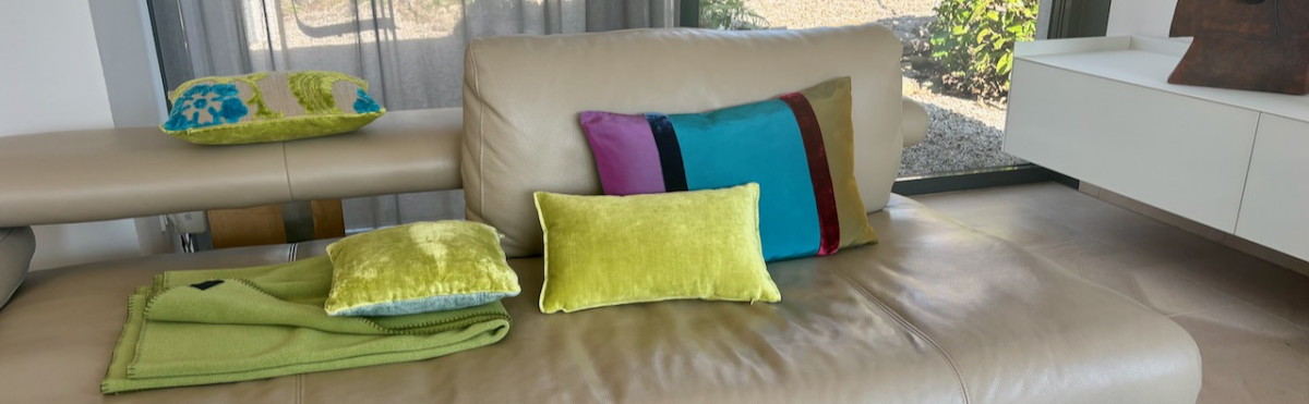 sofa mit kissen aus stoffen von designers guild und zimmer&rohde in frühlingsfarben. wolldecke von zoeppritz.