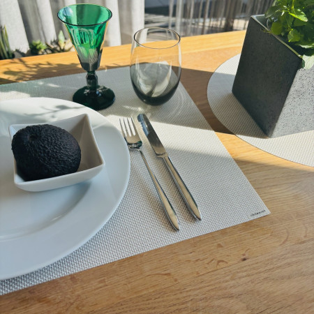 tischset von chilewich mit gedeck und avocado auf dem teller. dazu ein grünes glas im art deco stil