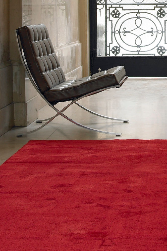 Ein ganz flacher Teppich aus rotem Velour.