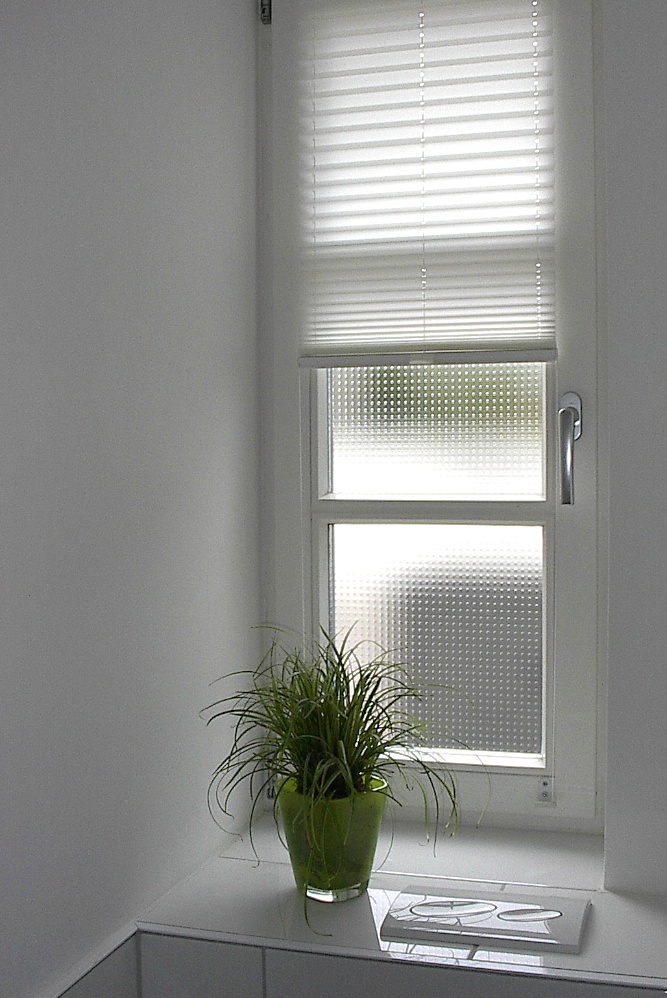 Plisseeanlage auf den Rahmen montiert macht weiches Licht im Bad.